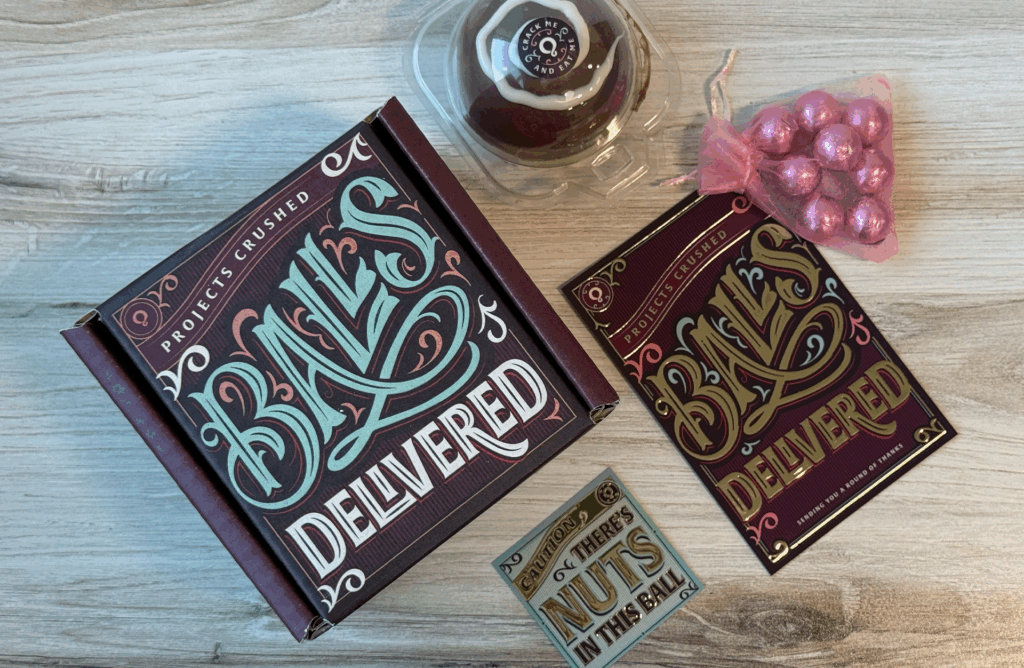 Holiday Packaging featuring a chocolate ball and cards with gold foil.