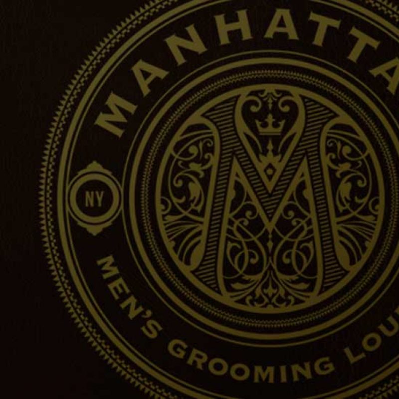 Manhattan Men's Grooming: Detailed circular logo and brand identity design for Manhattan Men’s Grooming Lounge in a gold and black color palette.