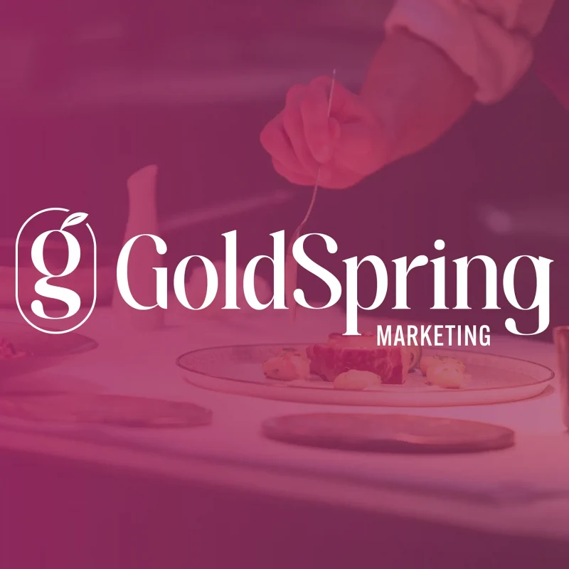 GoldSpring Marketing logo in white, a custom "g" monogram with a sprouting leaf beside the GoldSpring wordmark, over a magenta-tinted photo of a chef plating food.