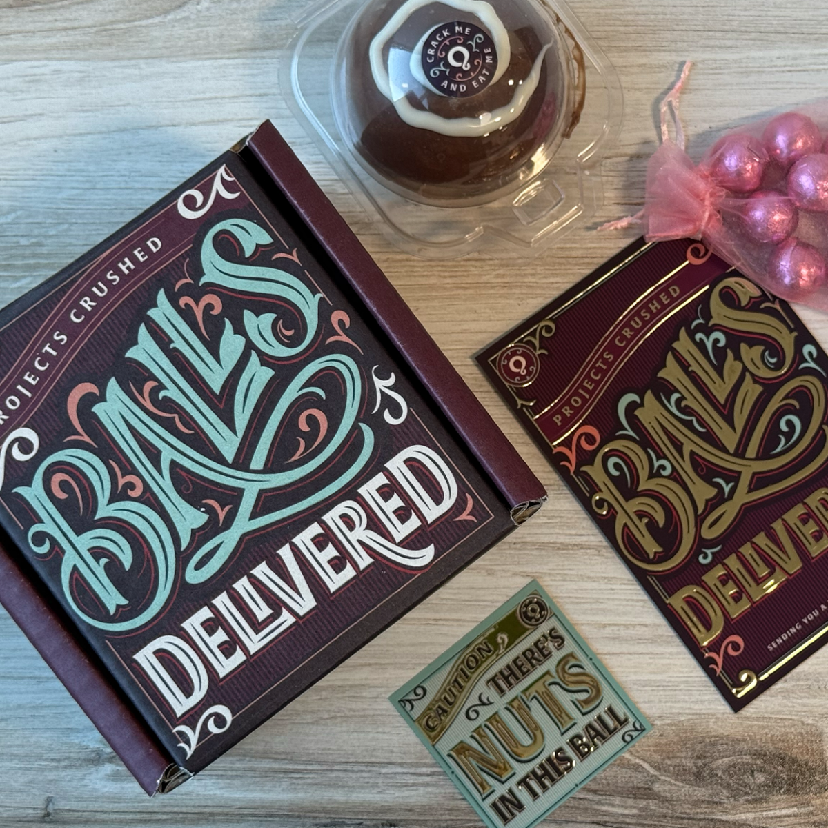 Holiday Packaging featuring a chocolate ball and cards with gold foil.